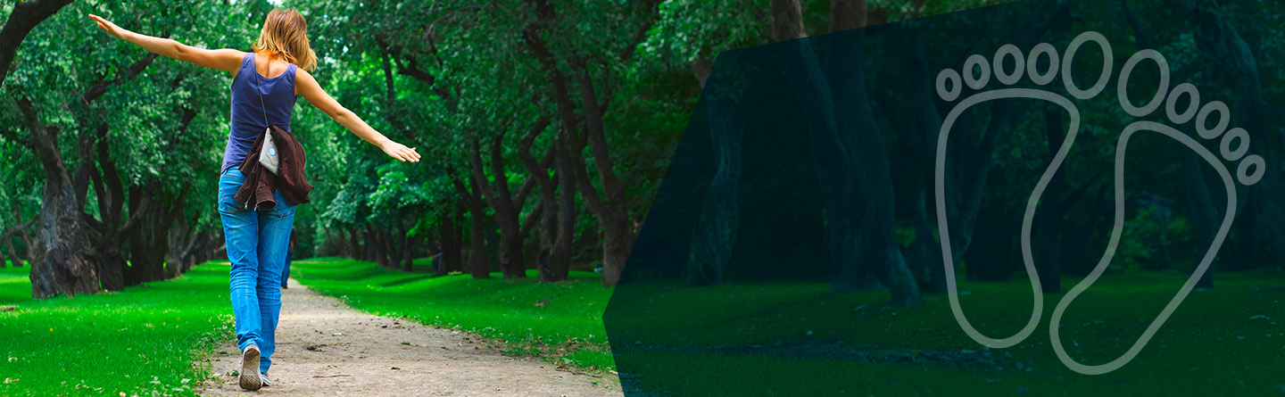 Header: Eine blau gekleidete Frau ist von hinten auf einem Feldweg zu sehen. Sie scheint zu balancieren.